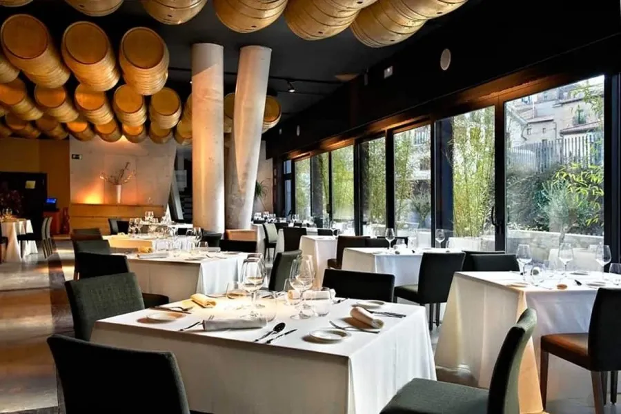 Bistró Barrica, Hotel Viura's restaurant, its tables laid in white linen under rows of oak barrels hung from the ceiling
