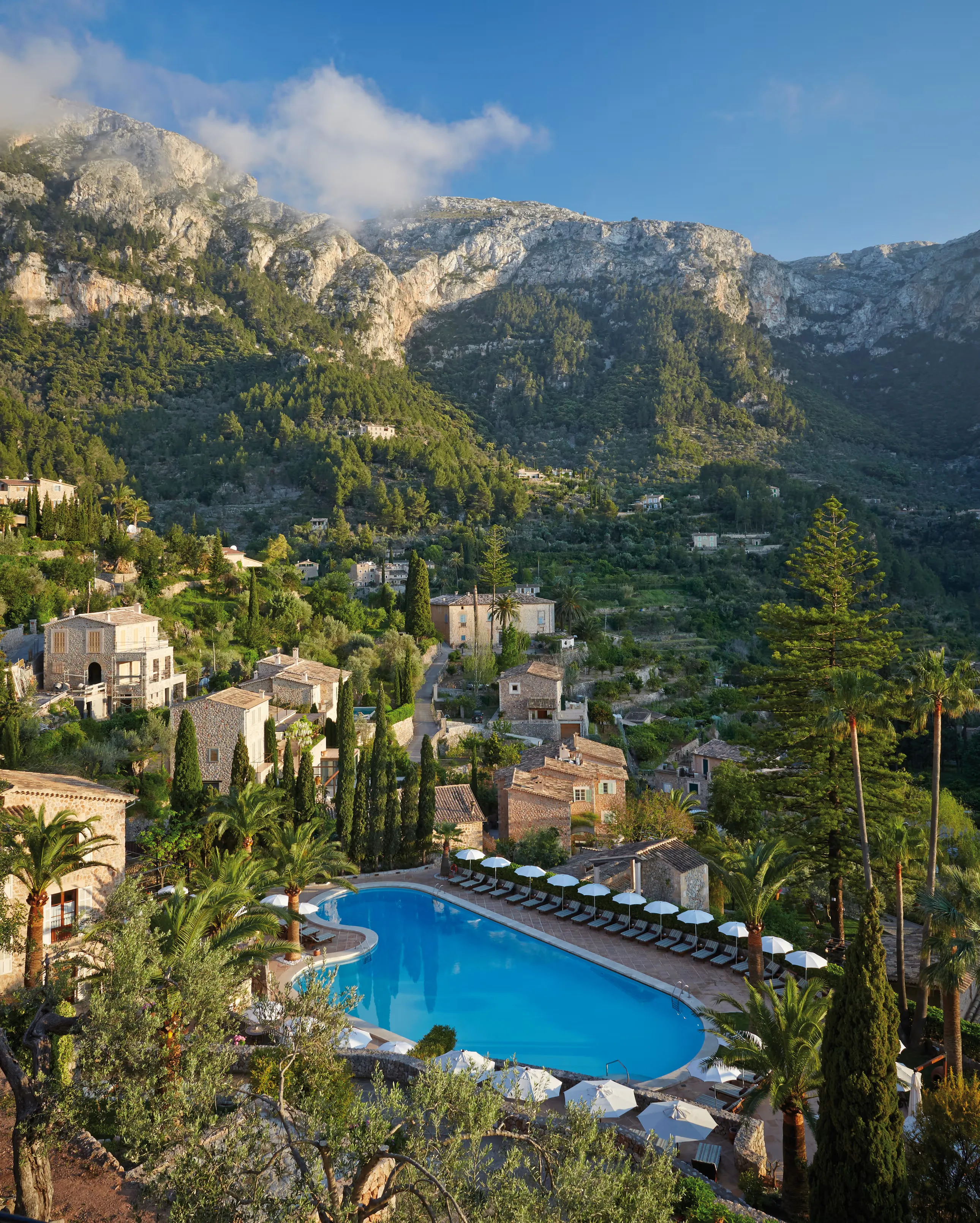 The outdoor pool at Belmond La Residencia, below the stone houses of Deià and the Tramuntana mountains