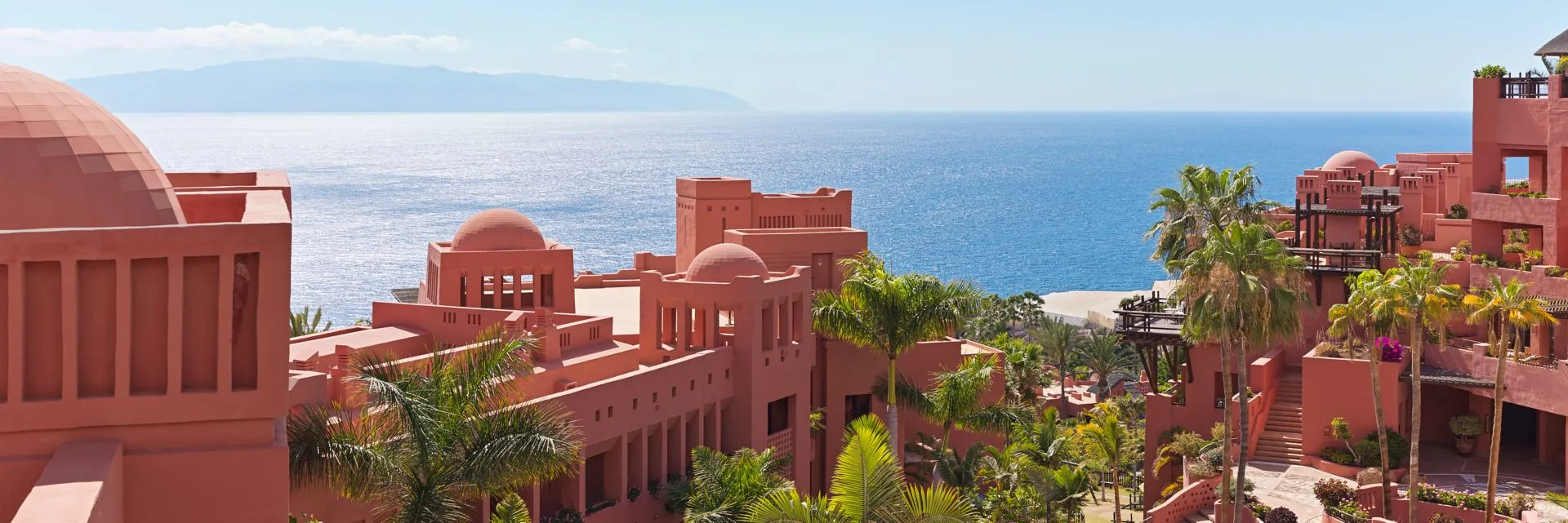 The resort's terracotta blocks and domes stepping down towards the Atlantic among palms, with the island of La Gomera low on the horizon