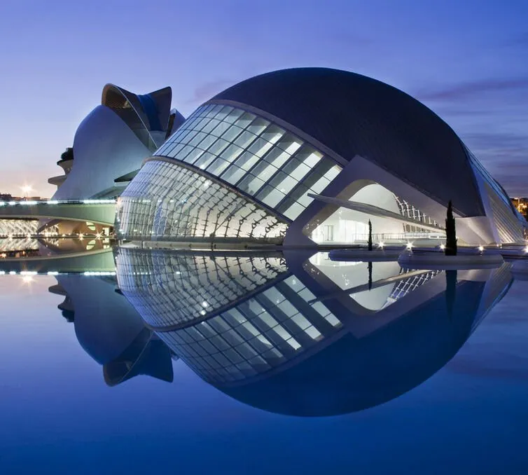 The Hemisfèric at Valencia's City of Arts and Sciences at dusk, its domed shell mirrored in the pool around it